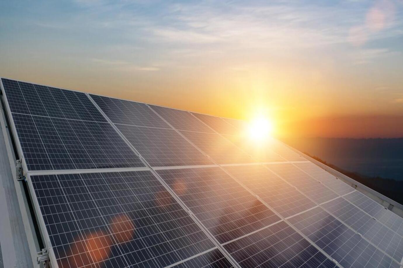 Sun rising up over rooftop with solar panels. More than solar panel blog image for Rochford area page. Installers of solar panels, EV chargers, air con, air source heat pumps and solar battery storage systems across Essex, London and Kent.